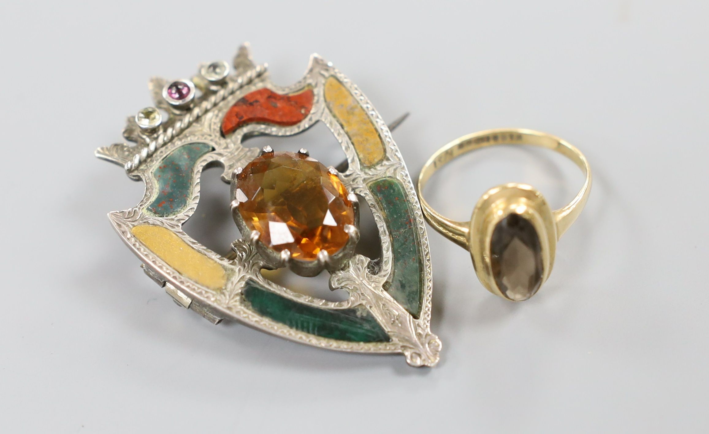 A modern 9ct gold mounted oval cameo shell brooch, 53mm, a 9ct gold and gem set ring and a white metal, gem and Scottish hardstone set shield shaped brooch